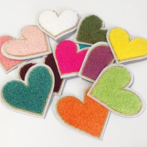 Puede incluir: Diez parches de corazón de fieltro de colores con ribete dorado. Los corazones son de varios colores, incluyendo rosa, blanco, verde, naranja, amarillo y morado.
