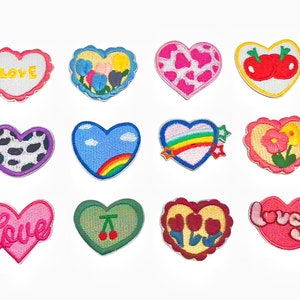 May include: Twelve heart-shaped iron-on patches with various designs, including flowers, cherries, rainbows, and the words "Love" and "Lovely".