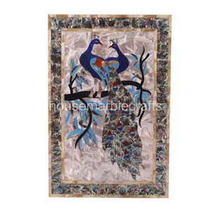 May include: A rectangular decorative panel featuring a mosaic of two peacocks perched on a branch. The birds are primarily blue with red and orange accents. The background is pearlescent, and the border is inlaid with iridescent shell pieces. The text "housemarblecrafts" is visible.