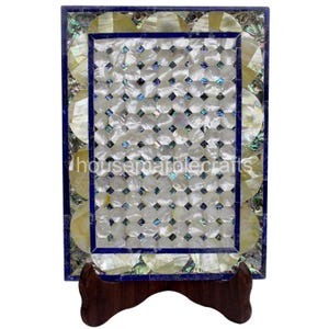 May include: Rectangular decorative tray with a mosaic pattern of white, iridescent, and blue shell pieces. The tray has a dark blue border and is supported by a dark brown wooden stand. The text "housemarblecrafts" is visible on the tray.