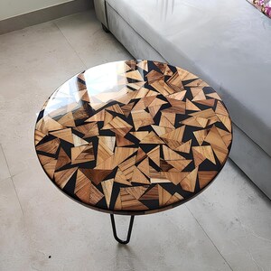 Zwarte epoxy salontafel: ronde eettafel met driehoekig patroon van houten blokken en harsmeubelen
