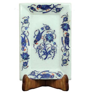 Könnte beinhalten: Rechteckige weiße Marmorschale mit aufwendigem blauem Vogel- und Blumen-Inlay-Design. Die Schale wird von einem Holzständer getragen. Das Design zeigt Vögel, Blumen und Ranken und schafft ein dekoratives Stück.