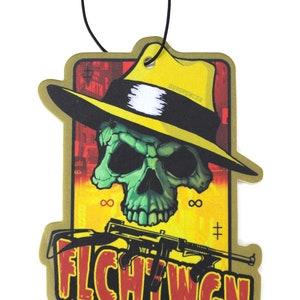 Könnte beinhalten: Ein goldener Auto-Lufterfrischer mit einem Totenkopf, der einen gelben Fedora trägt und eine Waffe hält. Der Text "FLCHTWGN" ist in Rot und Schwarz unten aufgedruckt.