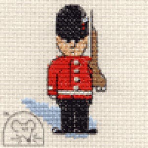 May include: A red and black toy soldier wearing a tall black hat and holding a rifle. The soldier is standing on a white background.