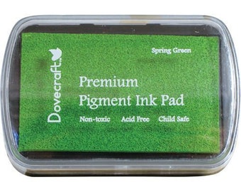 Puede incluir: Una almohadilla de tinta verde con el texto "Dovecraft Premium Pigment Ink Pad" y "Spring Green" en la parte delantera. La almohadilla de tinta es no tóxica, libre de ácidos y segura para niños.