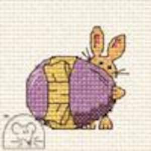 May include: A purple and yellow ball of yarn with a brown bunny peeking out from behind it. The bunny has pink ears and a brown nose.