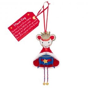 Pode incluir: Um enfeite de Natal com um design de rei rato. O rato usa uma coroa de ouro, uma capa vermelha e um tambor azul com uma estrela de ouro. Uma etiqueta vermelha com texto está pendurada no topo. O texto na etiqueta diz "Mouse King".