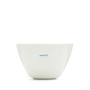 May include: A white ceramic cereal bowl with a slightly flared shape. The word "cereal" is printed in a small, light blue font on the side of the bowl. The bowl is empty and sits against a white background.