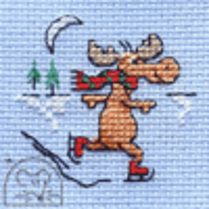 May include: A cross-stitch design of a moose ice skating on a blue background. The moose is brown with a red and green scarf and red ice skates. A crescent moon and two green trees are in the background.