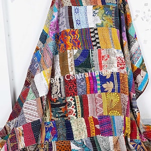 Könnte beinhalten: Eine farbenfrohe Patchwork-Decke aus recycelten Saris. Die Decke besteht aus vielen verschiedenen Farben und Mustern, darunter florale, geometrische und Paisley-Designs. Die Decke ist handgenäht und hat einen einzigartigen Vintage-Look.