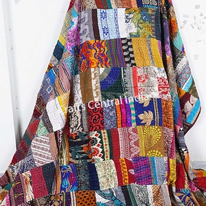 Könnte beinhalten: Eine farbenfrohe Patchwork-Decke aus recycelten Saris. Die Decke besteht aus vielen verschiedenen Farben und Mustern, darunter florale, geometrische und Paisley-Designs. Die Decke ist handgenäht und hat einen einzigartigen Vintage-Look.