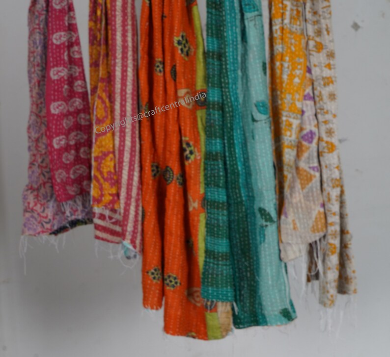 Puede incluir: Seis colchas kantha de colores colgando de una pared blanca. Las colchas est&aacute;n hechas de saris reciclados y presentan una variedad de patrones y colores, incluyendo rosa, naranja, amarillo, verde y azul. Copyright @craftcentralindia