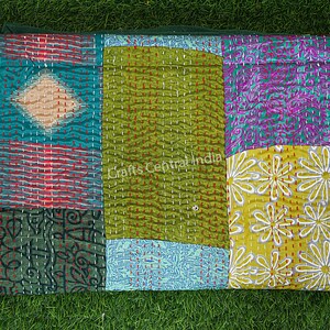 May include: A colorful patchwork quilt with a variety of floral and geometric patterns. The quilt is made of different fabrics sewn together and has a hand-stitched look. The quilt is green, blue, yellow, red, and purple.