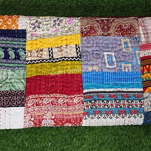 May include: A colorful patchwork quilt made from various fabrics with different patterns and colors. The quilt is made up of squares and rectangles of fabric sewn together. The quilt is a vibrant mix of colors, including red, blue, green, yellow, and orange.