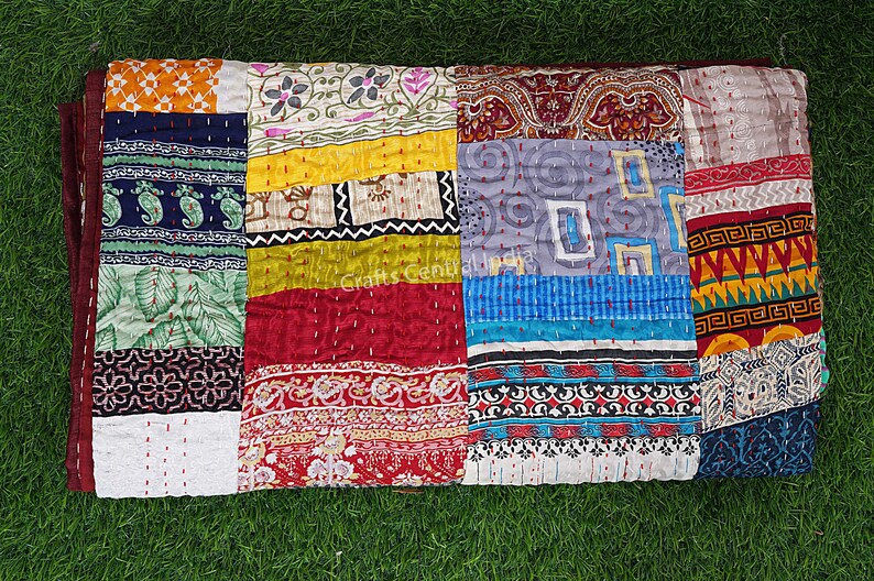 May include: A colorful patchwork quilt made from various fabrics with different patterns and colors. The quilt is made up of squares and rectangles of fabric sewn together. The quilt is a vibrant mix of colors, including red, blue, green, yellow, and orange.