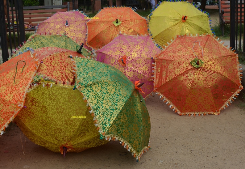 May include: A collection of colorful umbrellas with intricate patterns. The umbrellas are made of fabric and have a variety of colors, including red, orange, yellow, green, and blue. The umbrellas are arranged in a semi-circle, with the handles pointing towards the center.