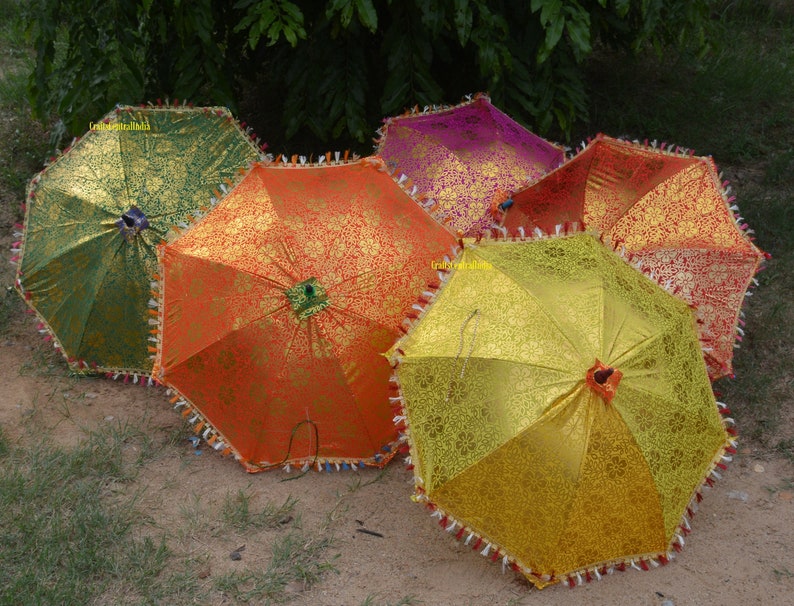 May include: Five colorful umbrellas with intricate patterns and fringed edges. The umbrellas are in shades of green, orange, yellow, pink, and red.