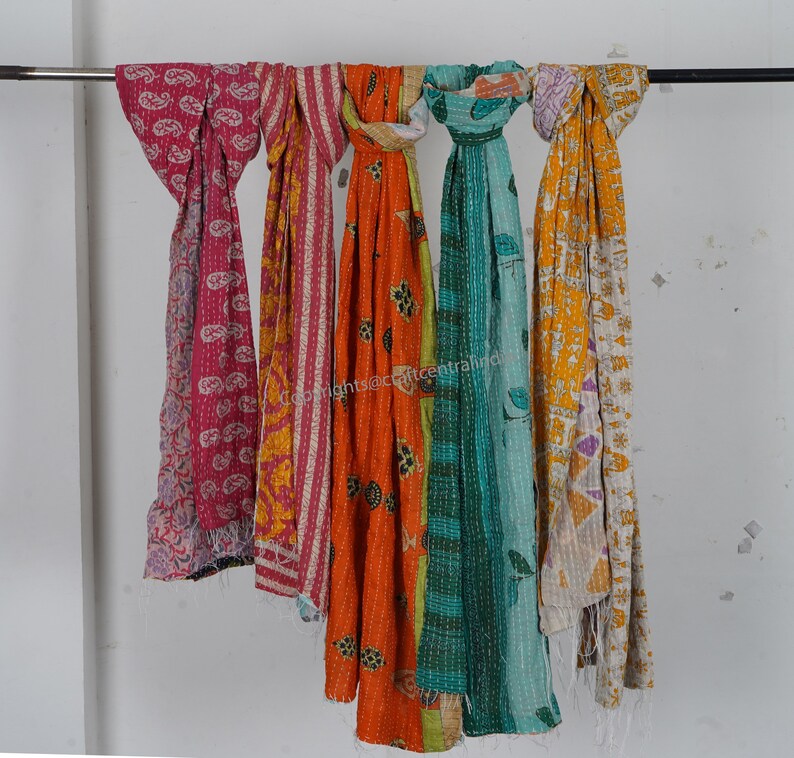 Puede incluir: Cinco bufandas kantha coloridas colgadas de una barra. Las bufandas est&aacute;n hechas de tela de retazos y tienen diferentes patrones, incluyendo dise&ntilde;os de paisley, florales y geom&eacute;tricos. Las bufandas son en tonos de rosa, naranja, amarillo, verde y azul.