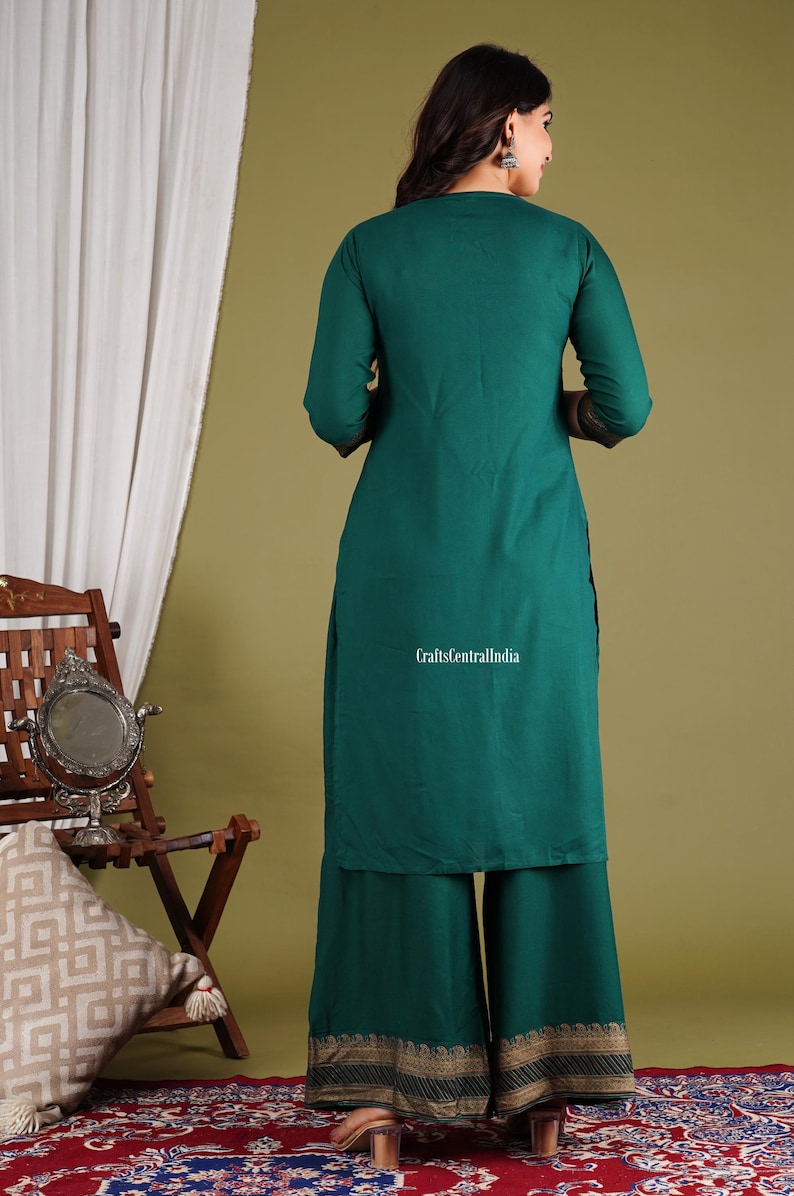 May include: A teal green kurta and palazzo set with gold embroidery. The set is made of a soft, flowy fabric and is perfect for a casual or semi-formal occasion. The model is wearing the set with a pair of gold earrings and a simple necklace.