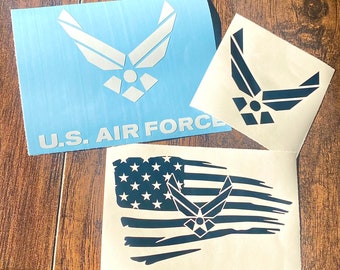 Puede incluir: Pegatinas con el emblema de la Fuerza Aérea de EE. UU. Una es de color azul claro con el texto "U.S. AIR FORCE". Otra muestra el emblema. Una tercera muestra la bandera estadounidense con el emblema.