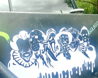 Puede incluir: Una superficie negra con un gráfico blanco y azul que presenta personajes icónicos de películas de terror, incluyendo un payaso, Jason Voorhees y Ghostface. El diseño tiene un efecto de goteo en la parte inferior.
