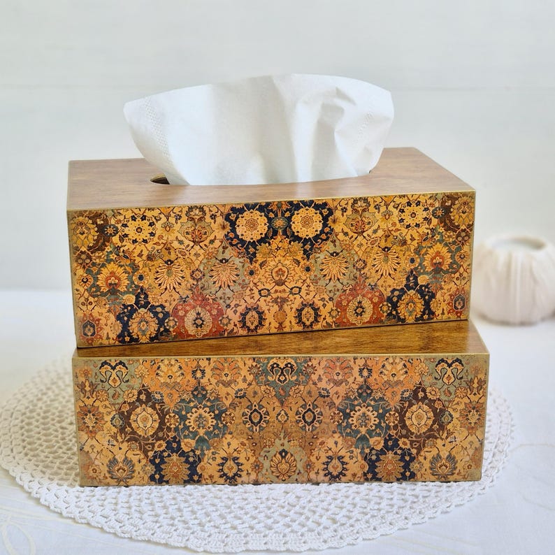 Pu&ograve; includere: Un copri scatola di fazzoletti in legno con un design a motivi colorati. La parte superiore della scatola &egrave; in legno marrone con un'apertura per i fazzoletti. La parte inferiore della scatola &egrave; un design a motivi colorati.
