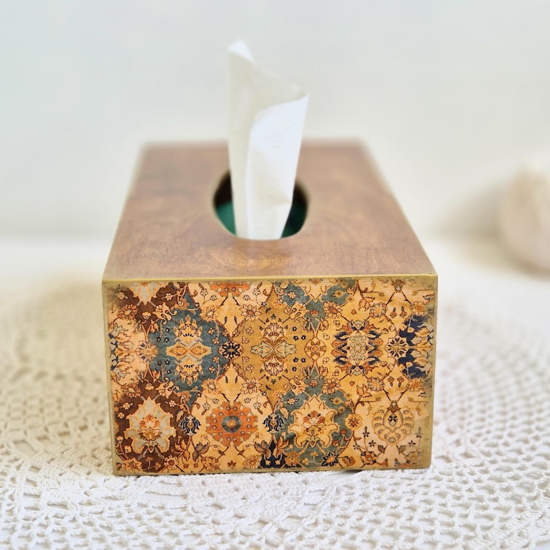 Pu&ograve; includere: Un porta fazzoletti in legno con un design a motivi in ​​toni marroni, blu e oro. Il porta fazzoletti ha una fessura per estrarre i fazzoletti.