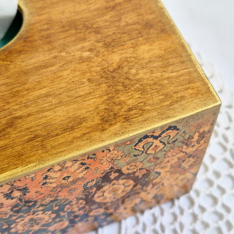 Pu&ograve; includere: Un copri scatola di fazzoletti in legno con un bordo dorato e un motivo floreale. La parte superiore della scatola &egrave; in legno massello.
