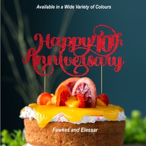 May include: Red glitter cake topper with the text "Happy 40th Anniversary". The topper is on a cake decorated with fruit and frosting.