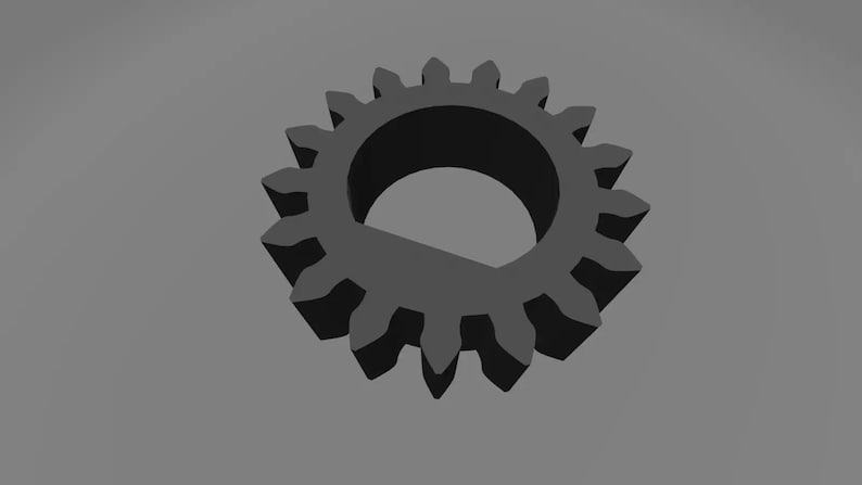 以下が含まれることがあります： 外側に歯が並んだ、中央に大きな穴のある黒い金属製の歯車です。