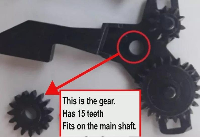 May include: A black plastic gear assembly featuring a separate small gear with 15 teeth. A red arrow points from a circular opening on the main assembly to the small gear. Text on the image reads: This is the gear. Has 15 teeth. Fits on the main shaft.