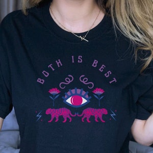 May include: Black t-shirt with the text "BOTH IS BEST" in pink and blue. The shirt features a design with an eye, flowers, and two pink tigers. The shirt is short-sleeved and appears to be made of cotton.