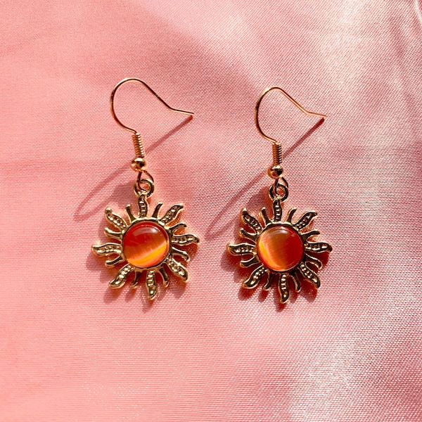 Bonitos y lindos pendientes de sol dorado brillante con piedras preciosas espirituales