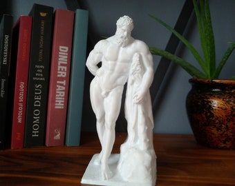 Puede incluir: Estatua blanca de una figura masculina desnuda de pie sobre una roca. La estatua está hecha de un material liso y blanco y tiene un aspecto realista. La figura está representada con barba y una pose relajada.