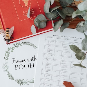 以下が含まれることがあります： 赤い「Winnie-the-Pooh」の本と「Primer with POOH」ガイドが、木製のクマとユーカリとともに表示されています。装飾的な蜂も存在します。子供向けの教育テーマです。サイズはcmです。