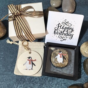 Affascinante arte di ciottoli di pinguino con sciarpa a righe, set regalo di pietre personalizzato con ornamento appeso, biglietto di auguri e scatola regalo