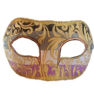 K&ouml;nnte beinhalten: Eine dekorative Maske mit einem verzierten Design. Die Maske hat ein Gold-, Schwarz-, Grau- und Lila-Farbschema. Die Augen&ouml;ffnungen sind braun umrandet. Die Maske ist mit goldener Filigranarbeit und einem goldenen Besatz verziert.