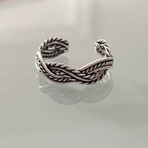 Puede incluir: Anillo de dedo del pie de plata con un diseño trenzado.