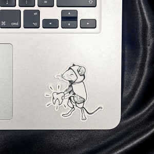 Sticker représentant la petite souris, style tatouage, collé sur un ordinateur pour donner une idée de l.échelle.