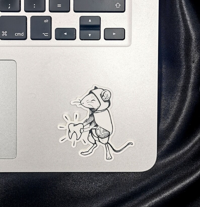 Sticker représentant la petite souris, style tatouage, collé sur un ordinateur pour donner une idée de l.échelle.