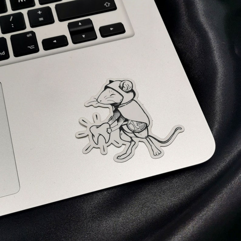 Sticker représentant la petite souris, style tatouage, collé sur un ordinateur pour donner une idée de l.échelle.
