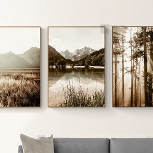 May include: Set of three sepia toned landscape photographs. The first image shows a mountain range with a field of tall grass in the foreground. The second image shows a lake with mountains in the background. The third image shows a forest with sunbeams shining through the trees.