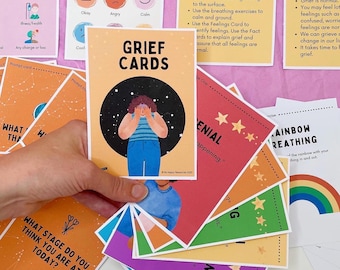 May include: A set of colorful cards with illustrations and text. The cards are titled "Grief Cards" and include phrases like "Denial" and "Rainbow Breathing".