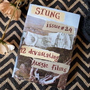 以下が含まれることがあります： 「STUNG issue #24」というタイトルの雑誌。コラージュの表紙で、「12 devastating Aussie films」と書かれています。背景は黒と茶色のシェブロン柄で、花のアクセントがあります。