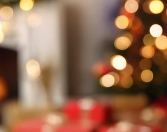 May include: Blurred image of a Christmas scene with a decorated tree, presents, and festive lights. The tree is adorned with ornaments and lights, and red gift boxes are visible in the foreground. Warm, golden bokeh lights create a soft, inviting atmosphere.