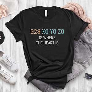 May include: Black t-shirt with the text "G28 XO YO ZO is where the heart is" in orange, blue, and white.