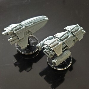 K&ouml;nnte beinhalten: Zwei graue Miniatur-Raumschiffe auf schwarzen Sockeln. Die Raumschiffe haben detaillierte Designs und sind aus Kunststoff.