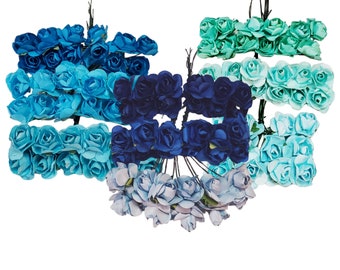 May include: Assortment of paper flower heads in blue, teal, and light blue colors. The flowers are arranged in bunches and are ready to be used for crafting projects.