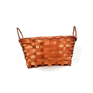 May include: A rectangular brown woven basket with two arched handles. The basket is made of thin, interwoven strips of wood, creating a textured surface. The basket is empty and sits against a white background.