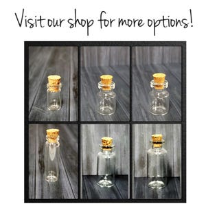May include: Six clear glass bottles with cork stoppers. The bottles are arranged in two rows of three. The bottles are all the same size and shape.